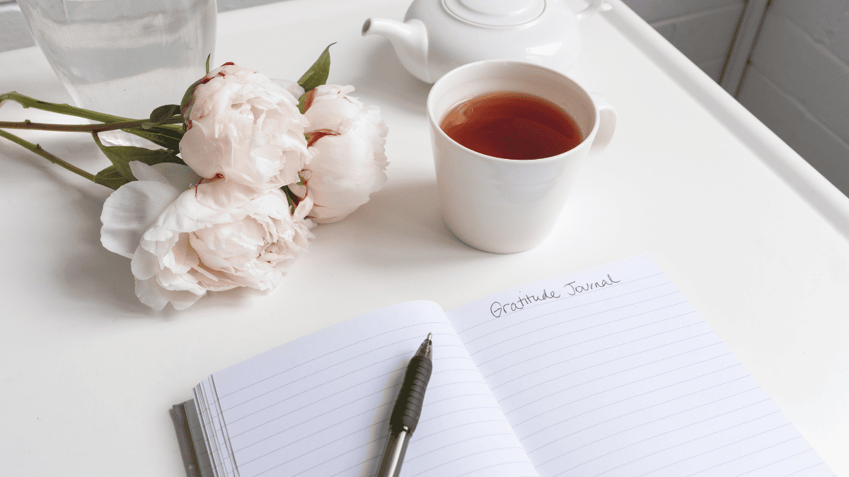 Image of a desk with notepad and pen and tea